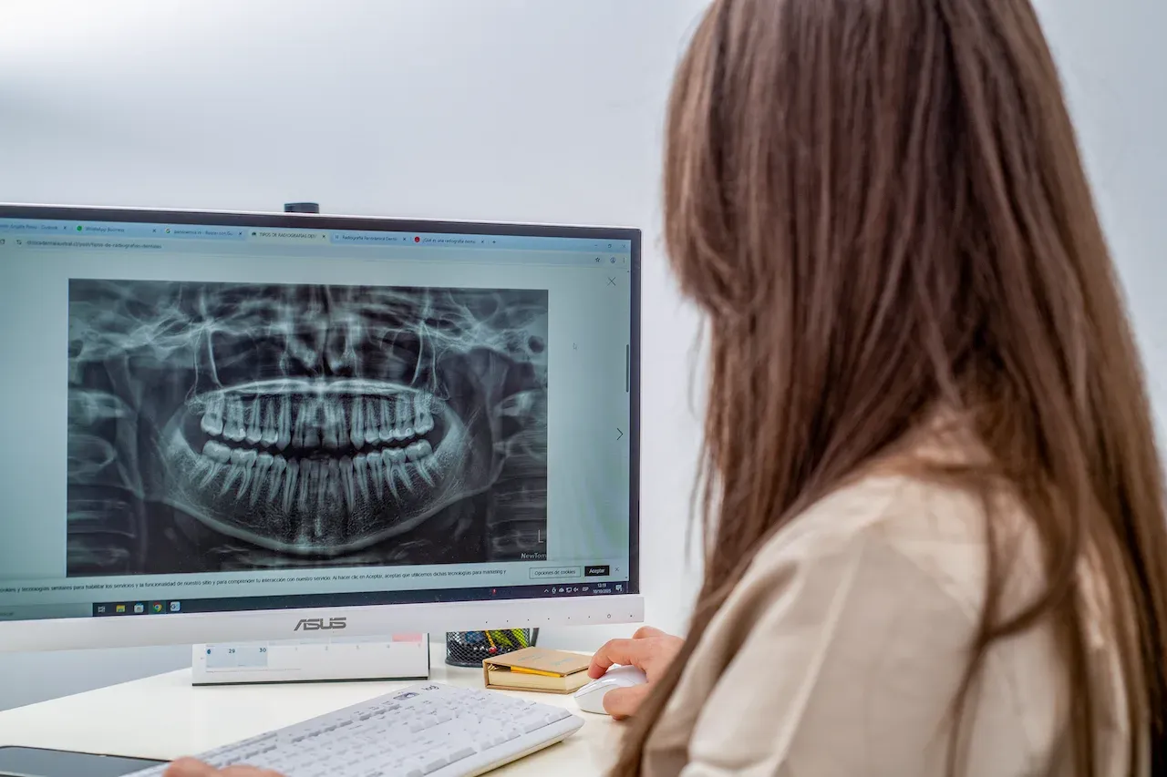 Profesional odontológica analizando una radiografía dental en el ordenador en Koura Dental Plus Madrid.