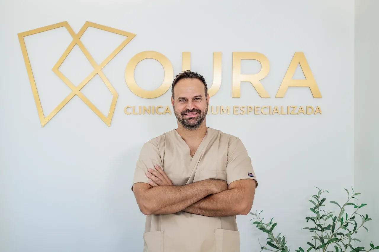 Profesional de la salud dental posando junto al logotipo de Koura Dental Plus en Madrid.
